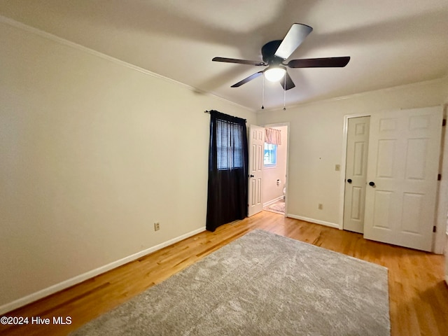 unfurnished bedroom with ceiling fan, crown molding, and hardwood / wood-style flooring