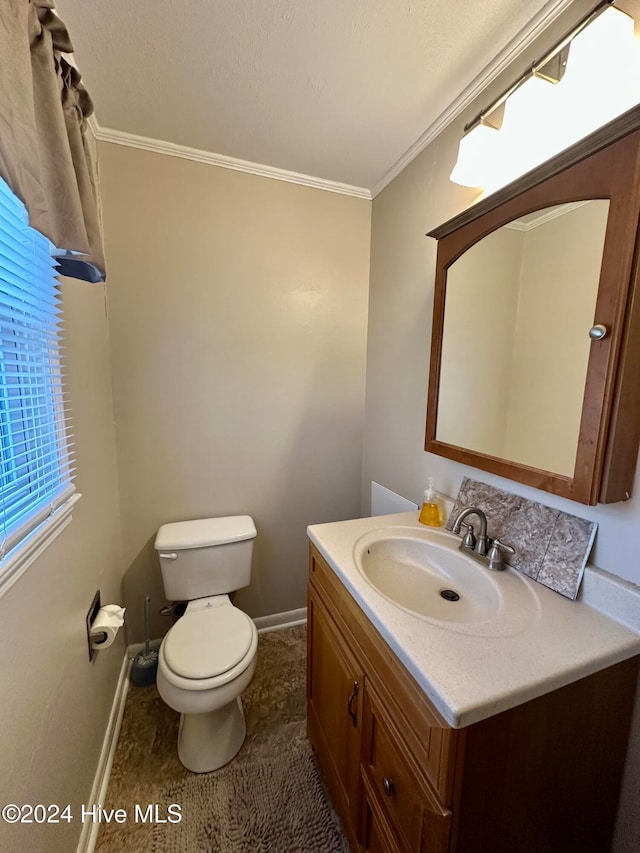 bathroom with toilet, vanity, and ornamental molding