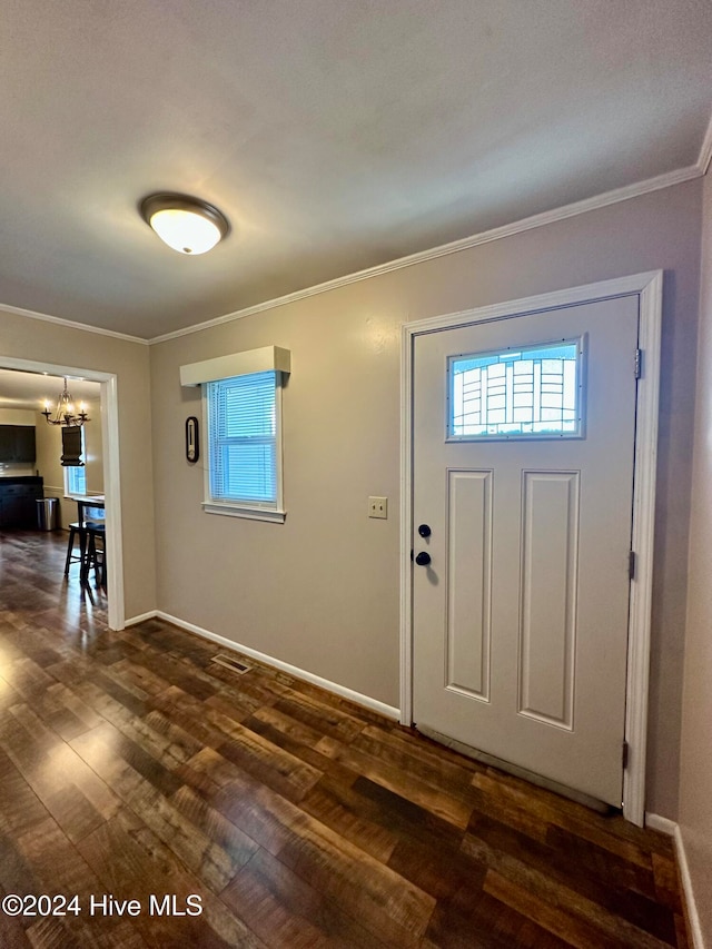 foyer featuring a chandelier, dark wood-type flooring, and ornamental molding