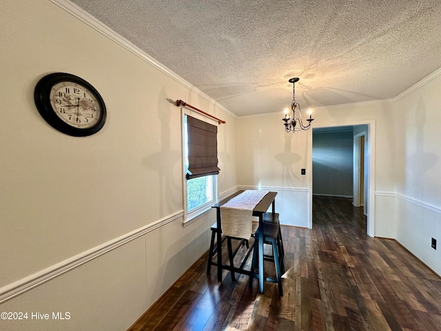 dining area with a textured ceiling, dark hardwood / wood-style floors, and ornamental molding