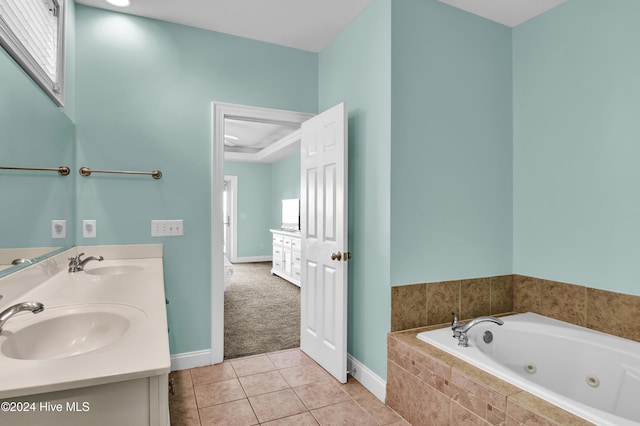 bathroom featuring tile patterned flooring, vanity, and tiled tub