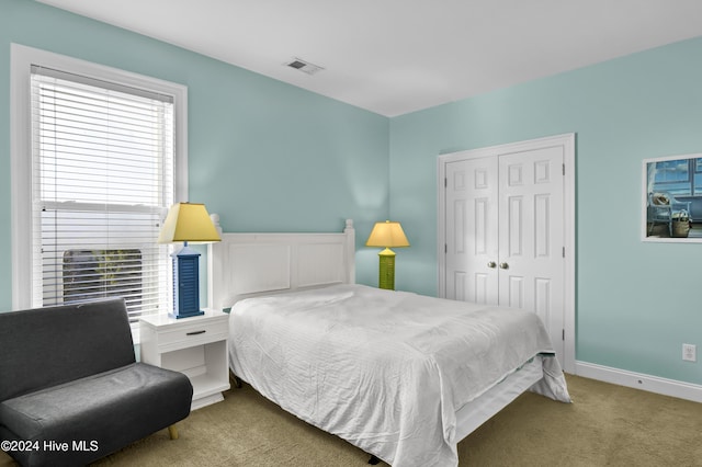 bedroom with light colored carpet and a closet