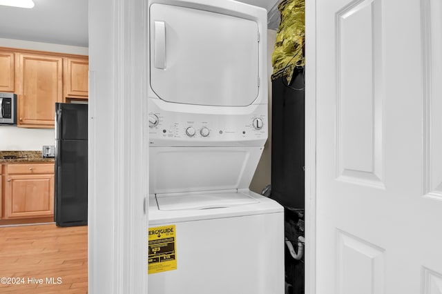 clothes washing area with stacked washer / dryer and light hardwood / wood-style flooring