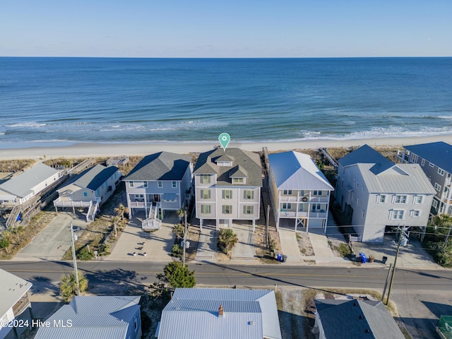 birds eye view of property with a water view and a beach view