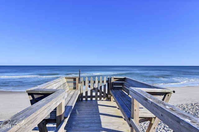 view of home's community with a water view and a beach view