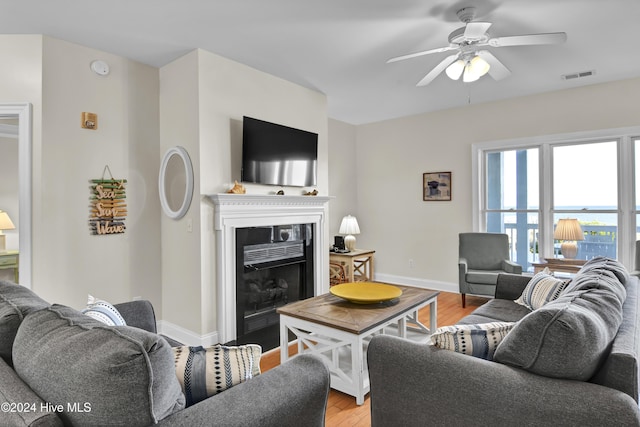 living room with light hardwood / wood-style flooring and ceiling fan