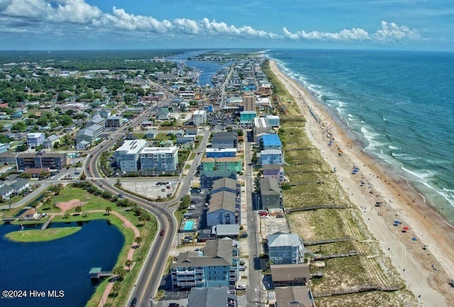 birds eye view of property with a water view and a beach view