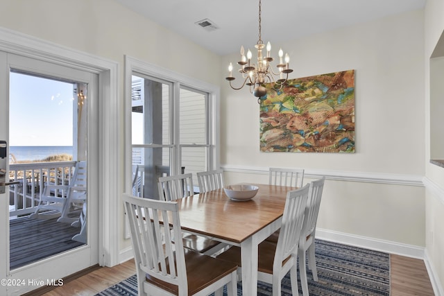 dining space featuring hardwood / wood-style floors and an inviting chandelier