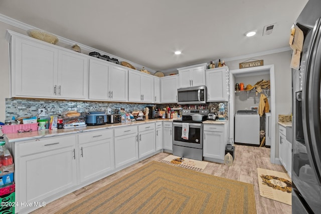 kitchen with washer / clothes dryer, crown molding, white cabinets, and stainless steel appliances