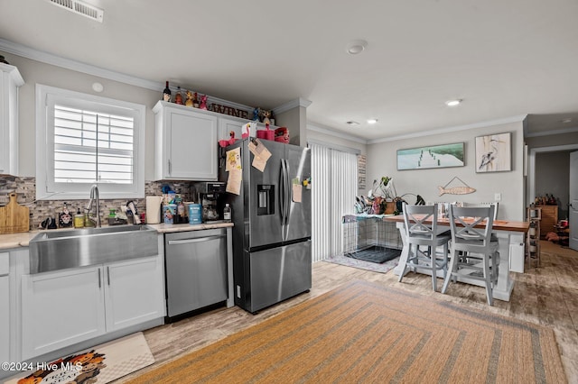 kitchen featuring white cabinets, appliances with stainless steel finishes, light hardwood / wood-style flooring, and sink