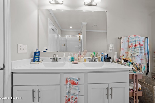 bathroom featuring vanity, a shower with door, and ornamental molding