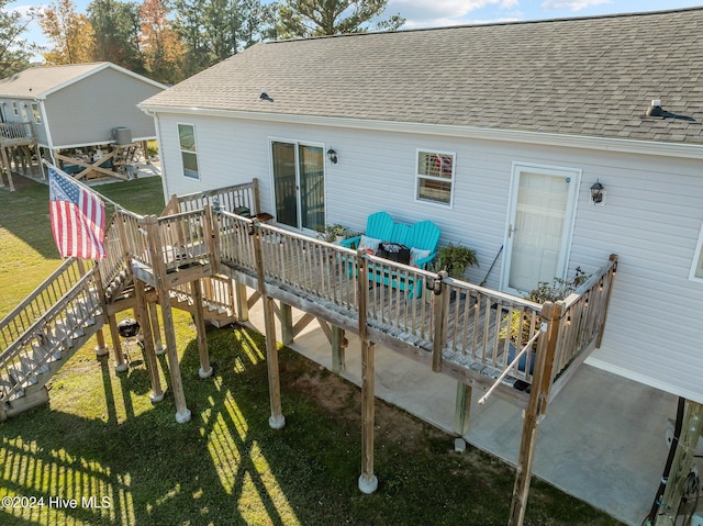 back of property featuring a deck and a yard