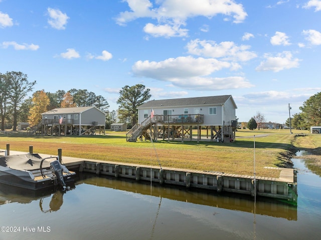 back of house featuring a deck with water view and a yard