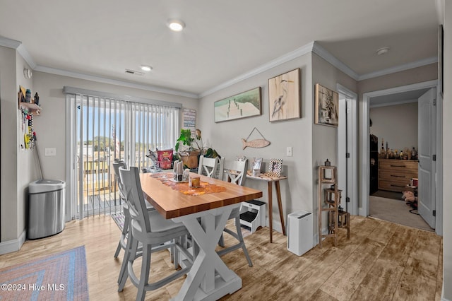 dining area featuring light hardwood / wood-style flooring and crown molding