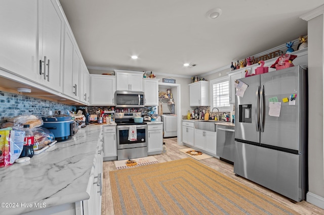 kitchen with sink, white cabinets, stainless steel appliances, and light hardwood / wood-style floors