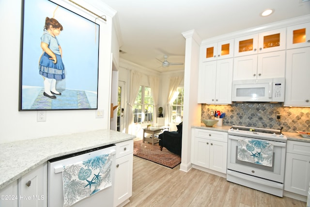 kitchen featuring light stone counters, ornamental molding, white appliances, light hardwood / wood-style flooring, and white cabinetry