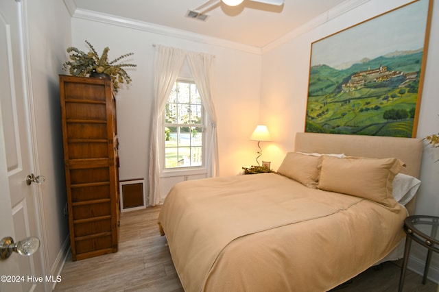 bedroom featuring ceiling fan, light wood-type flooring, and crown molding