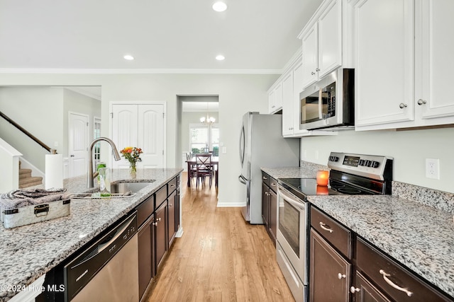 kitchen with sink, light hardwood / wood-style floors, dark brown cabinets, white cabinets, and appliances with stainless steel finishes