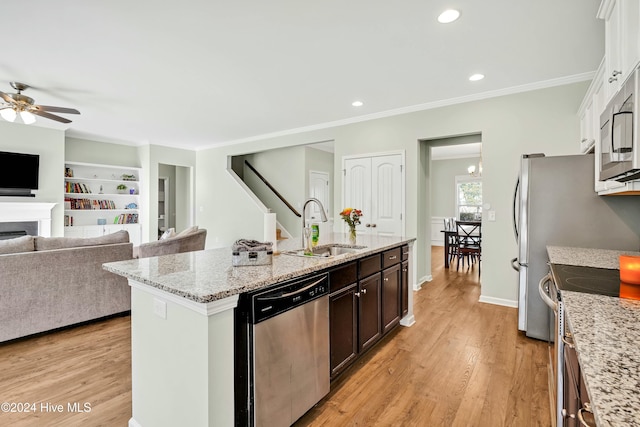 kitchen featuring light stone counters, sink, light wood-type flooring, and stainless steel appliances