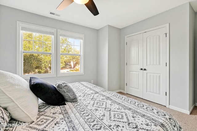 carpeted bedroom featuring ceiling fan and a closet