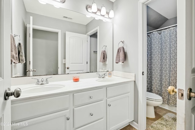 bathroom featuring vanity, toilet, and curtained shower