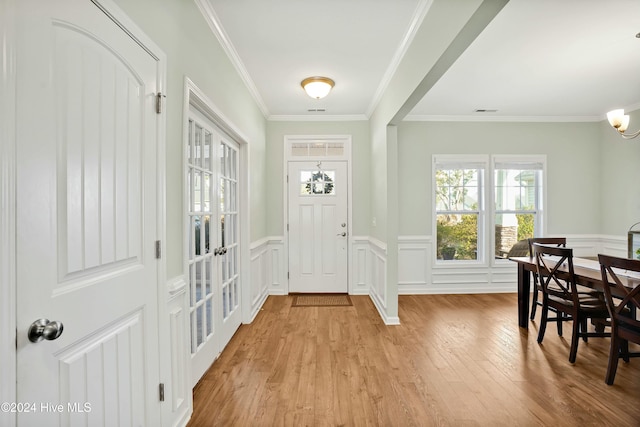 entrance foyer featuring crown molding and light hardwood / wood-style floors