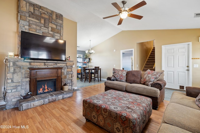 living room with ceiling fan, a fireplace, light hardwood / wood-style floors, and lofted ceiling