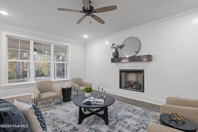 living room featuring a fireplace, ceiling fan, hardwood / wood-style floors, and ornamental molding