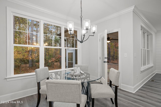 dining area featuring an inviting chandelier, hardwood / wood-style flooring, crown molding, and a healthy amount of sunlight