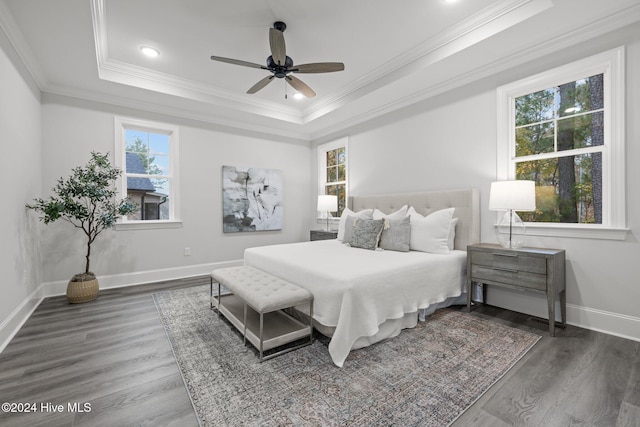 bedroom with a raised ceiling, ceiling fan, dark wood-type flooring, and ornamental molding