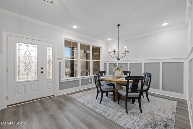 dining area featuring a chandelier, wood-type flooring, and ornamental molding