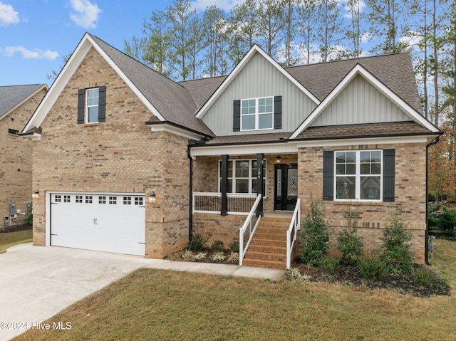 craftsman house with covered porch, a garage, and a front lawn