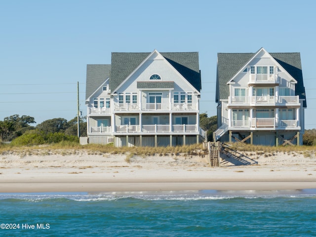 rear view of property with a beach view and a water view