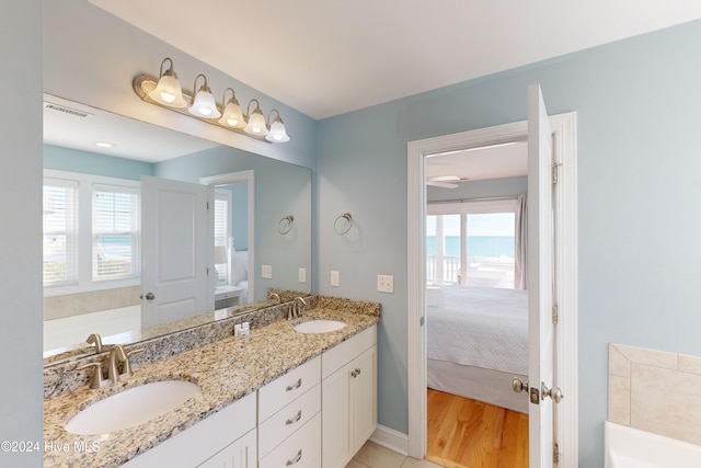 bathroom with vanity, a wealth of natural light, hardwood / wood-style floors, and a water view