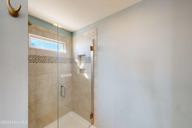 bathroom featuring a shower with door