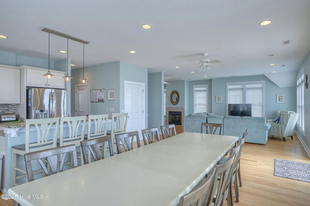 4316 Island Dr, North Topsail Beach, NC 28460 - dining room with ceiling fan, light wood-style flooring, recessed lighting, and a fireplace