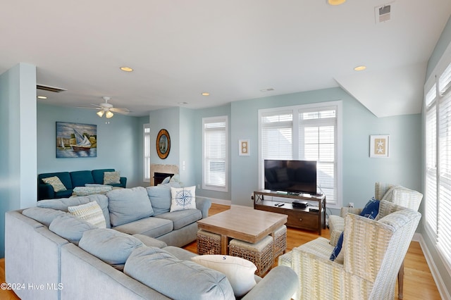 living room featuring ceiling fan and light hardwood / wood-style flooring