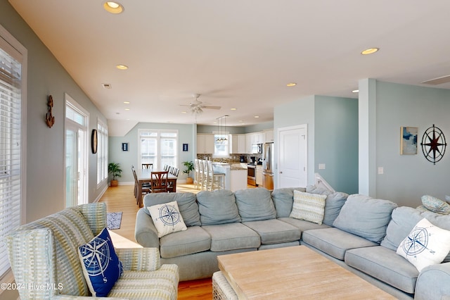 living room with ceiling fan and light wood-type flooring