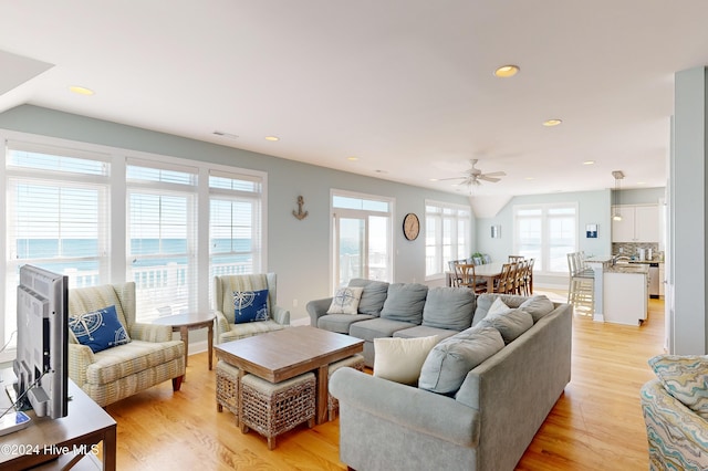 living room with light hardwood / wood-style flooring and ceiling fan