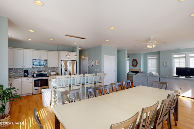 dining space featuring light wood-type flooring and ceiling fan