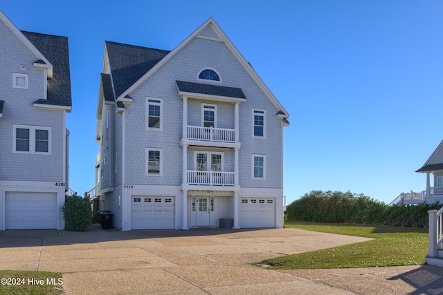 view of front of property with a garage, central air condition unit, a balcony, and a front yard