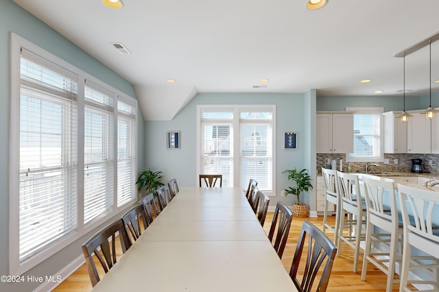 dining area with light hardwood / wood-style floors and lofted ceiling