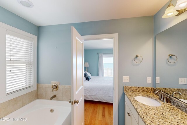 4316 Island Dr, North Topsail Beach, NC 28460 - ensuite bathroom featuring vanity, a garden tub, and wood finished floors