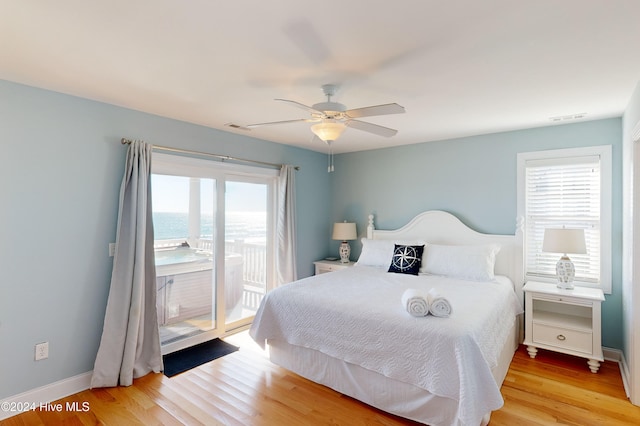 bedroom featuring ceiling fan, light hardwood / wood-style flooring, access to outside, and multiple windows