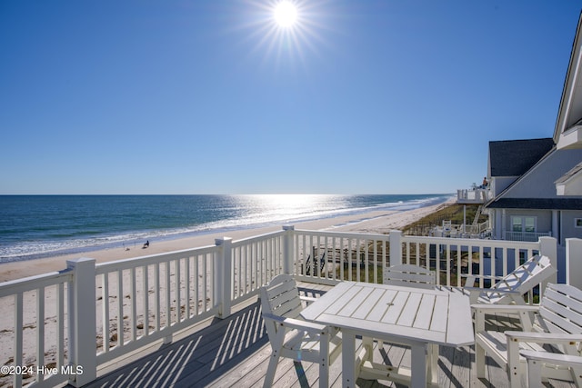 wooden deck with a beach view and a water view