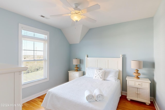 bedroom with ceiling fan, hardwood / wood-style floors, and lofted ceiling