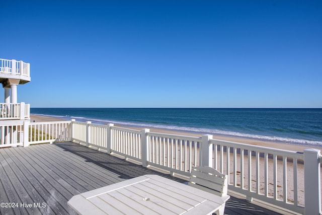 deck featuring a view of the beach and a water view