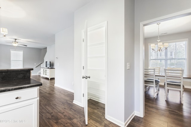 kitchen featuring white cabinetry, decorative light fixtures, dark hardwood / wood-style floors, and ceiling fan with notable chandelier