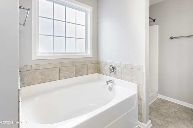 bathroom with tile patterned flooring, a bathtub, and a healthy amount of sunlight