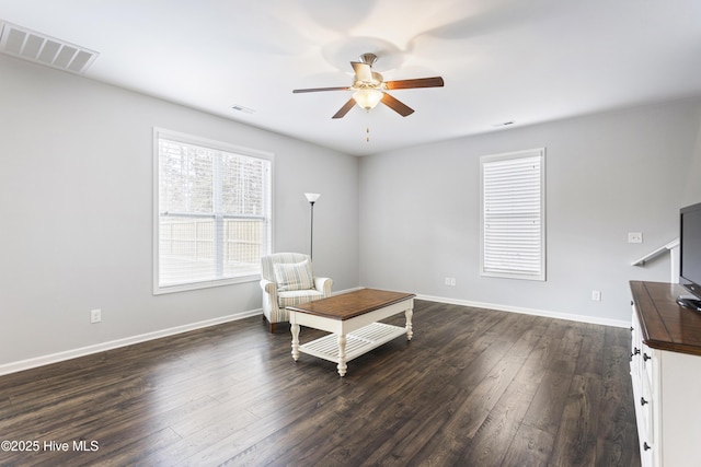 sitting room with ceiling fan and dark wood-type flooring